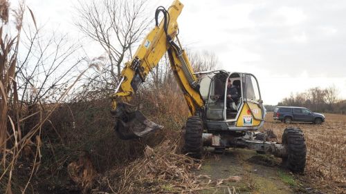 Ein großer Bagger steht am Feldrand