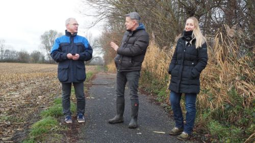 Hier stehen drei Projektbeteiligten auf einem Feldweg